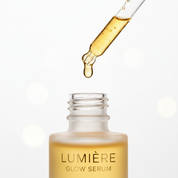 Lumière Glow Serum dropper close-up with golden serum drop